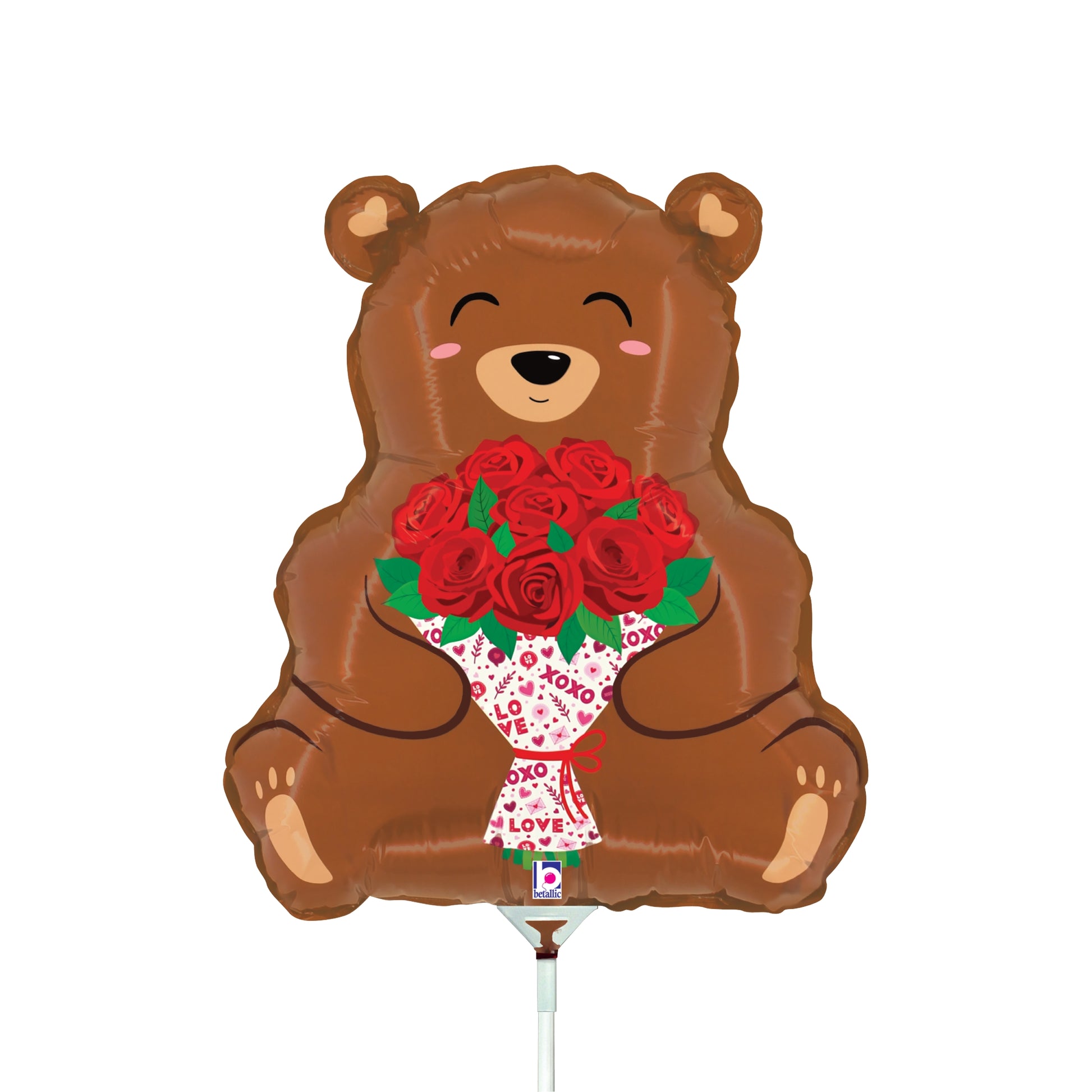 Brown bear-shaped foil balloon holding a bouquet of red roses with green leaves and white wrapping.