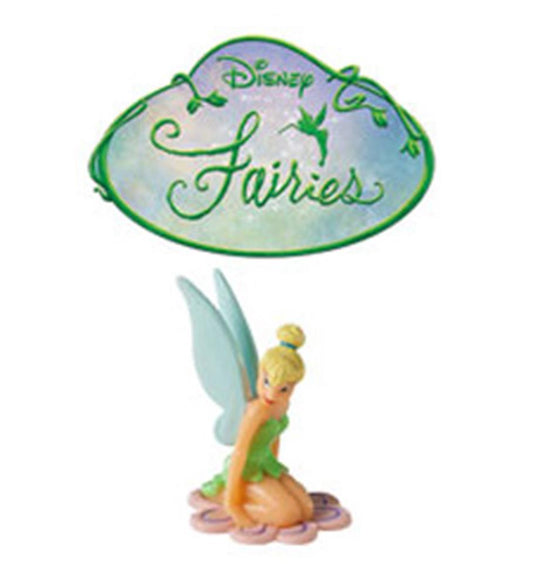 Tinkerbell figurine cake topper with green dress and translucent wings sitting on pink flower base, with green Disney.