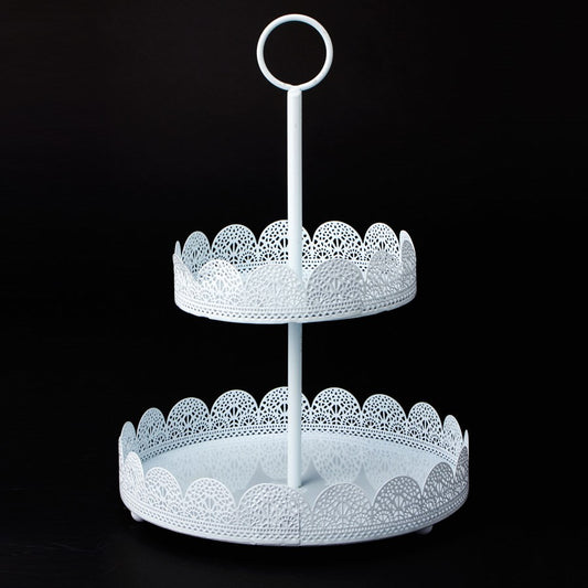 White two-tier metal treat stand with decorative eyelet lace edges and central handle ring.