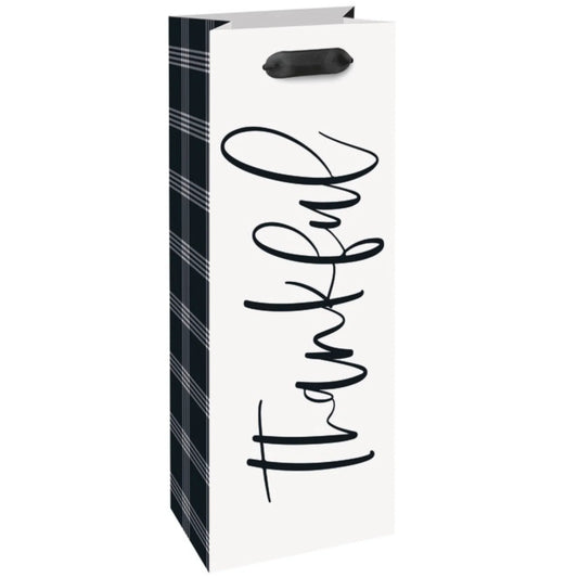 White paper wine gift bag with black plaid sides and "thankful" in black script, black ribbon handles.