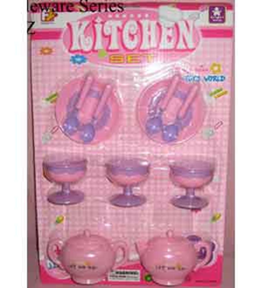 Pink plastic toy tableware set with two plates, utensils, three dessert cups, and two teapots on pink backing card.
