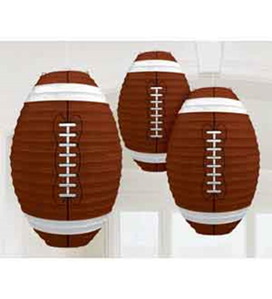 Three brown paper lanterns shaped like classic footballs with white laces and stripes hanging from strings.