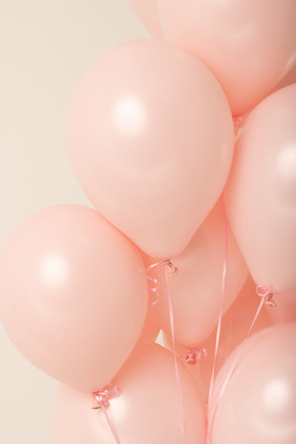 Pale pink 11-inch latex balloon with a smooth, glossy surface inflated with helium.