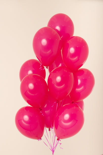 Cluster of bright pink, shiny latex balloons inflated with helium, each about 11 inches wide.