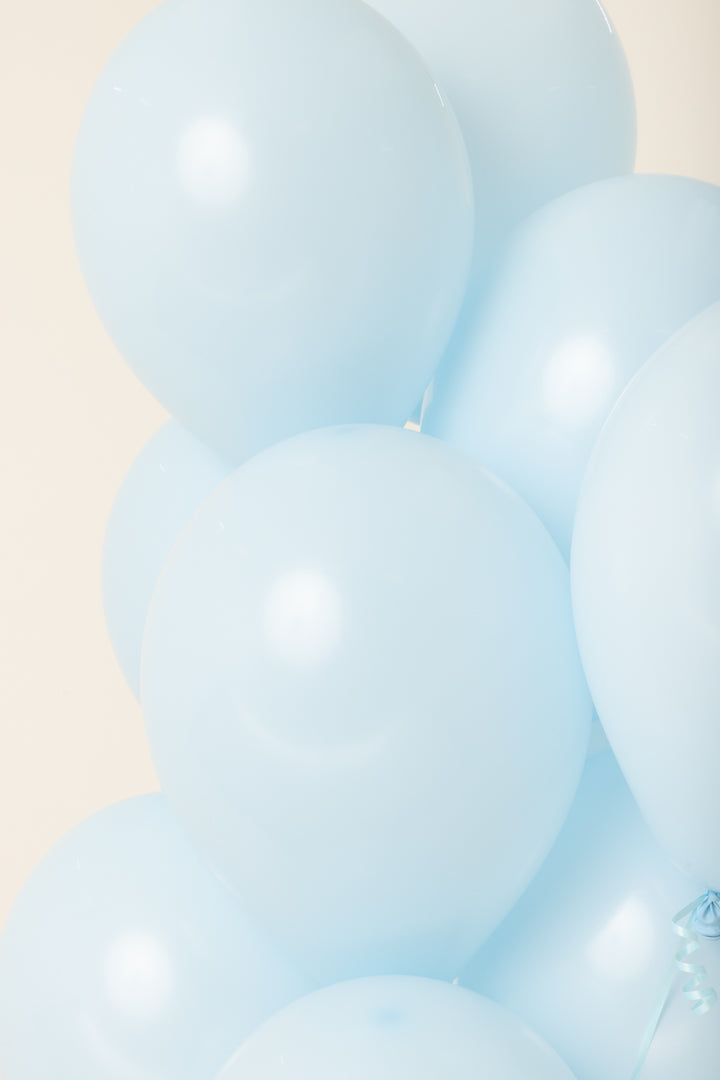 Cluster of light blue, round 11-inch latex helium balloons with a smooth, glossy surface.