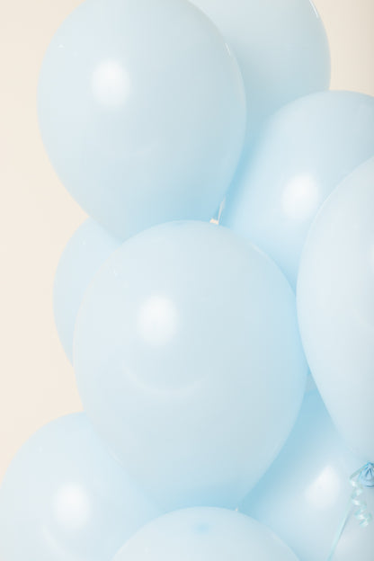 Cluster of light blue, round 11-inch latex helium balloons with a smooth, glossy surface.