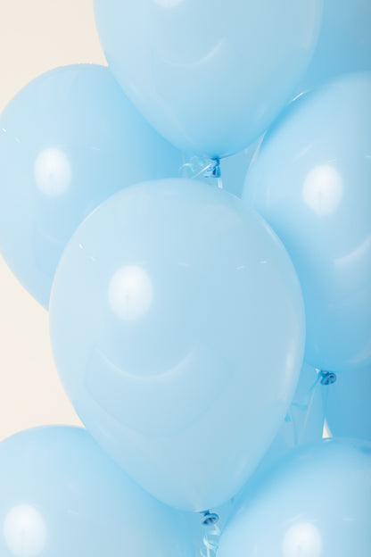 Light blue, shiny 11-inch latex balloon inflated with helium, round shape.