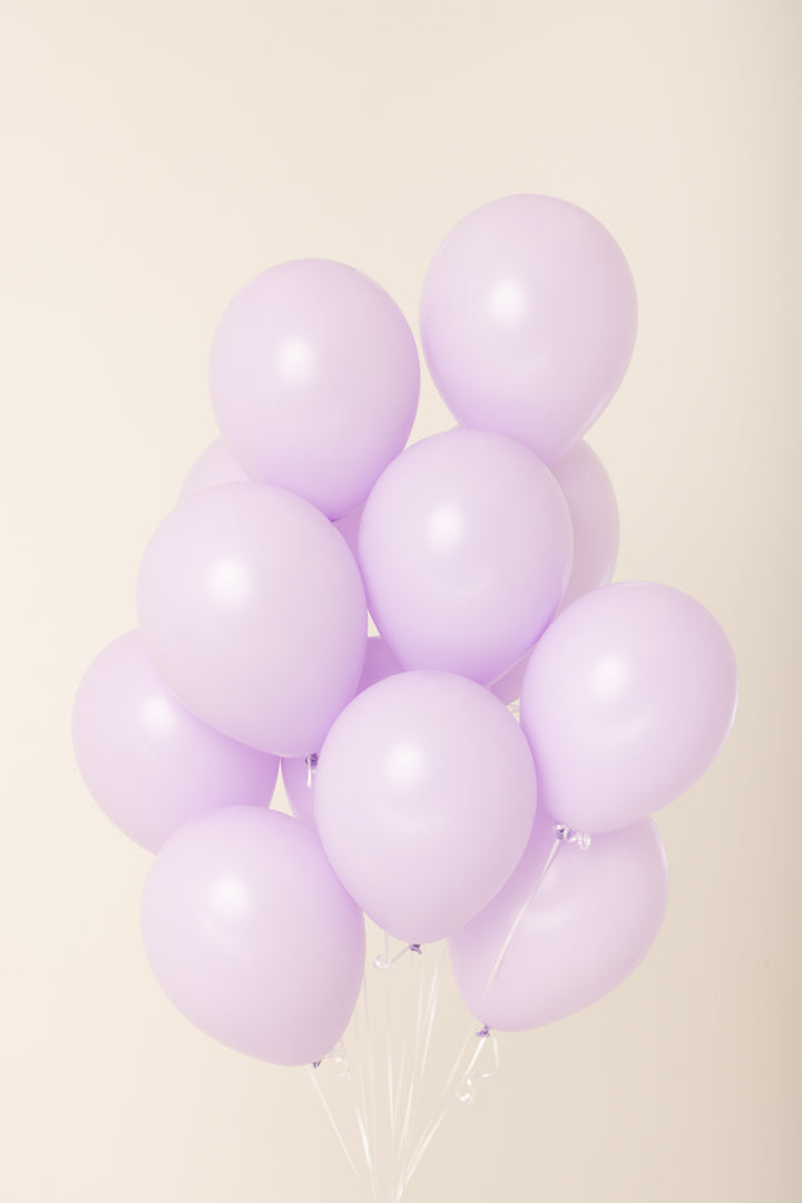 Cluster of ten light purple helium-filled latex balloons, 11 inches each, floating with white strings.