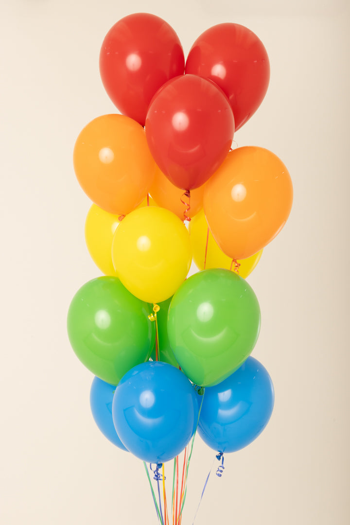 Cluster of 11-inch latex balloons in red, orange, yellow, green, and blue, helium inflated.