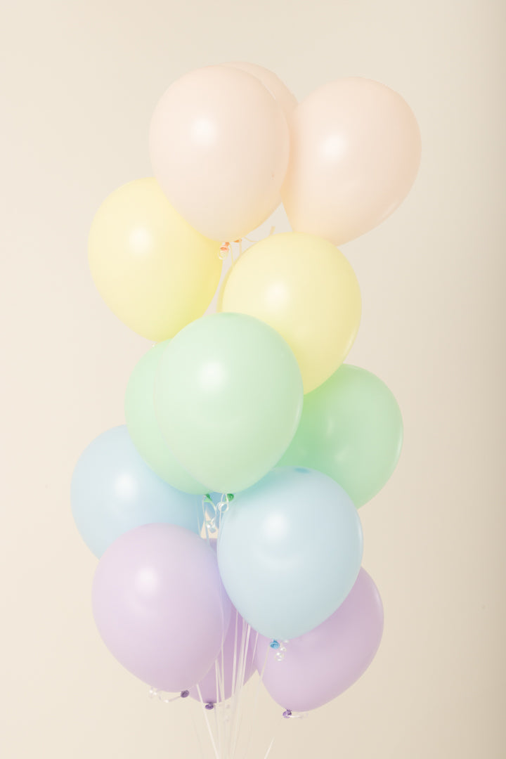 Cluster of pastel-colored 11-inch latex balloons inflated with helium in pink, yellow, green, blue, and purple.