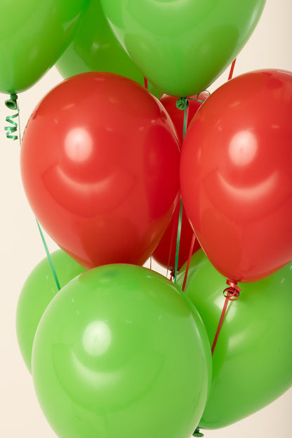 Glossy red and green latex balloons inflated and tied with curling ribbons.