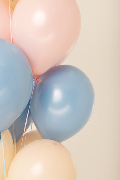 Set of 11-inch round latex balloons in pastel pink, blue, and cream colors inflated with helium.