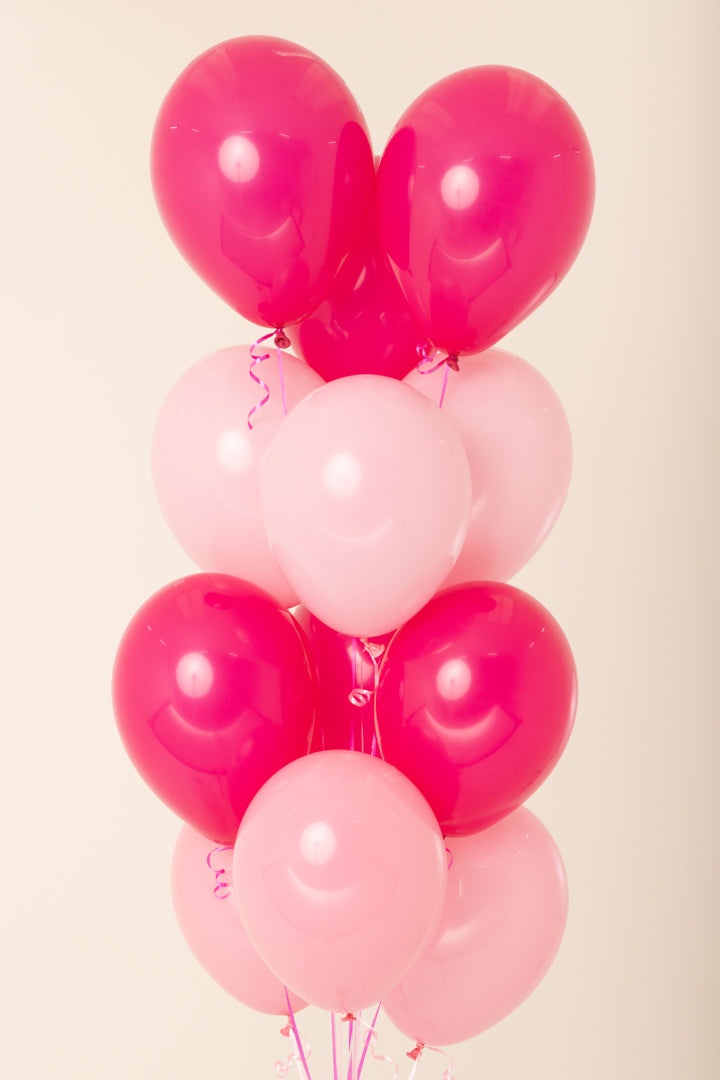 Cluster of 11-inch helium latex balloons in alternating bright pink and light pink colors with curled ribbons.