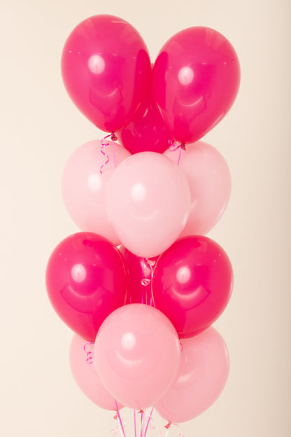 Cluster of 11-inch helium latex balloons in alternating bright pink and light pink colors with curled ribbons.