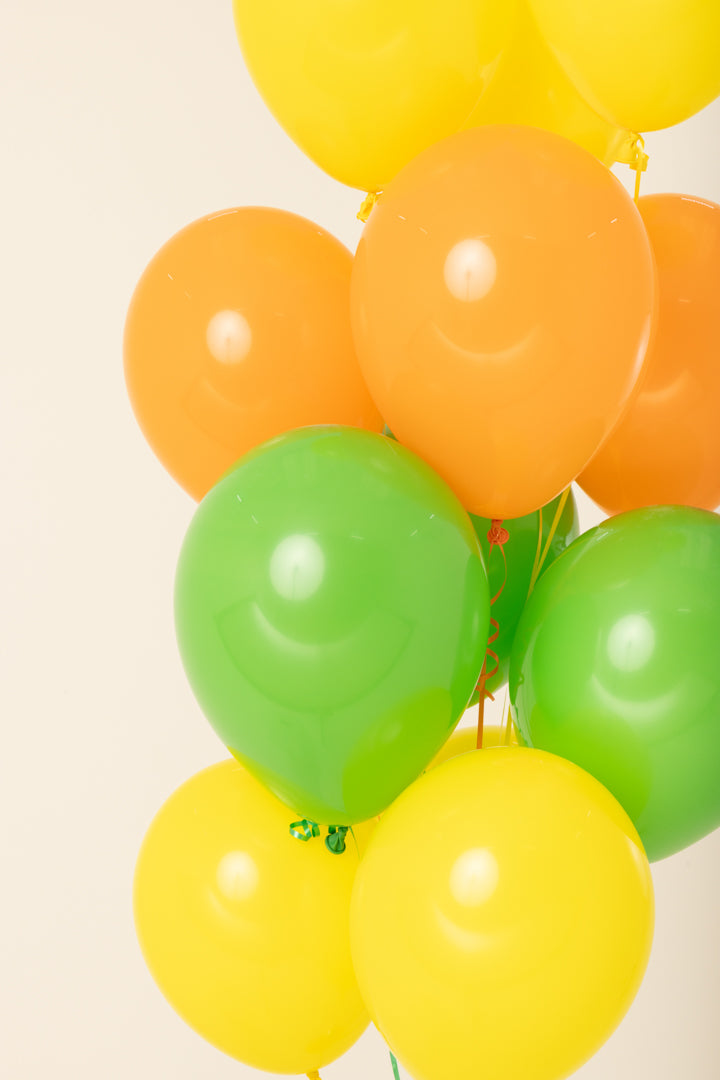 Cluster of 11-inch latex balloons in bright yellow, green, and orange, helium inflated.