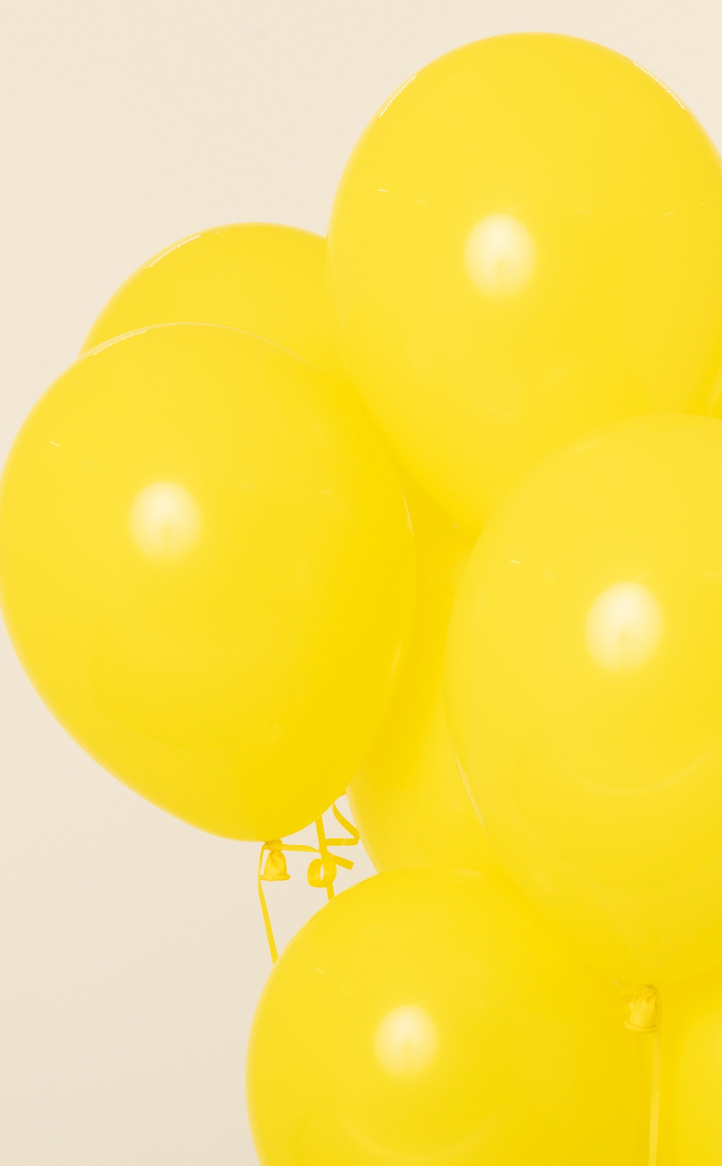 Bright yellow 11-inch round latex balloon inflated with helium.