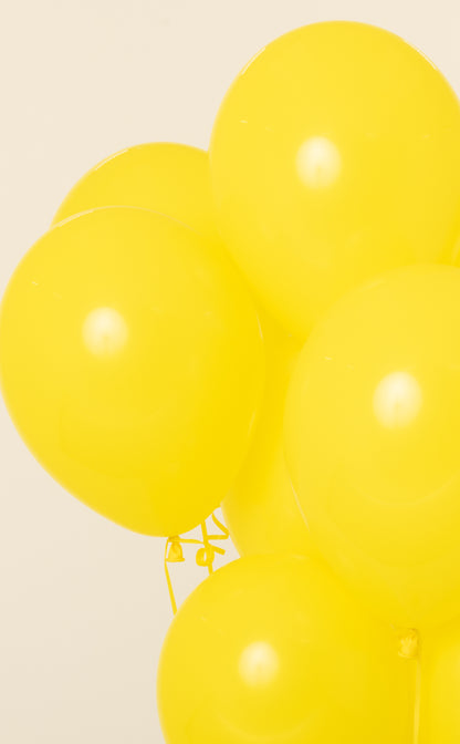Bright yellow 11-inch round latex balloon inflated with helium.