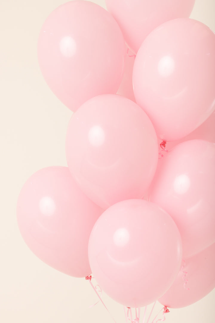 Cluster of helium-inflated 11-inch latex balloons in soft pastel pink.