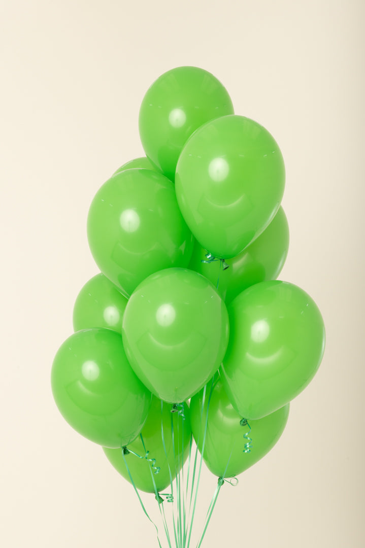 Bright green latex balloons, 11 inches, inflated and clustered together with strings.