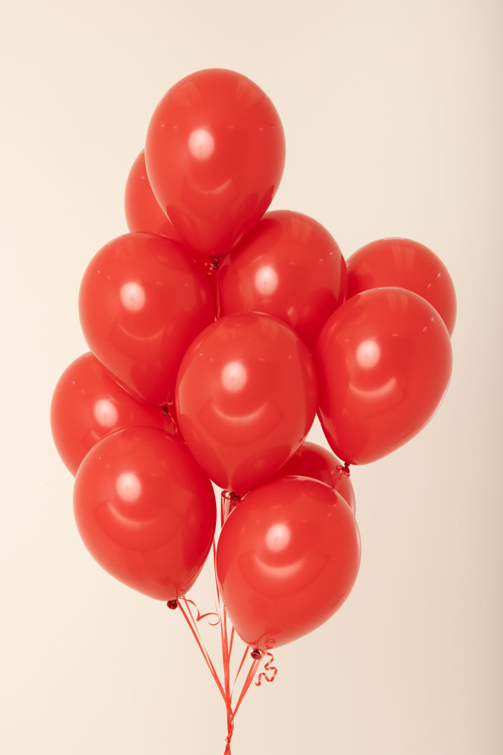 Cluster of shiny red latex balloons inflated with helium, each 11 inches in size.