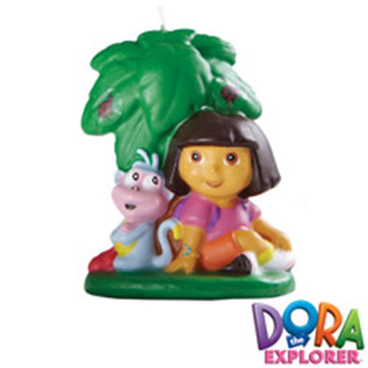 Colorful birthday candle featuring Dora the Explorer sitting with a purple backpack and character Boots under green leaves.