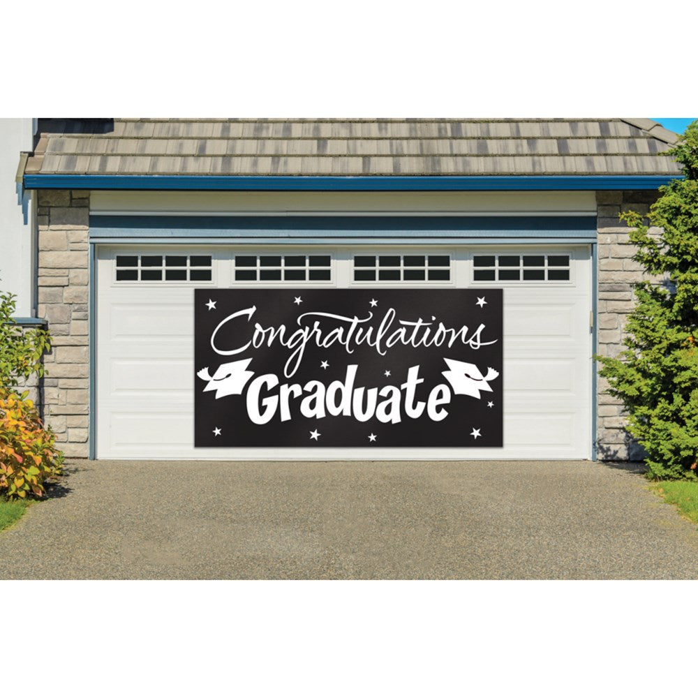 Large black graduation banner with white "Congratulations Graduate" lettering and decorative stars and caps.