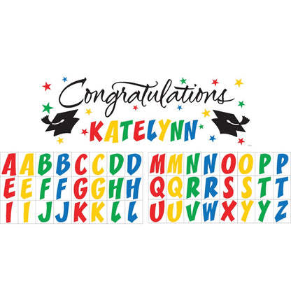 Colorful giant graduation party banner with "Congratulations Katelynn" text, black graduation caps, and multicolored.