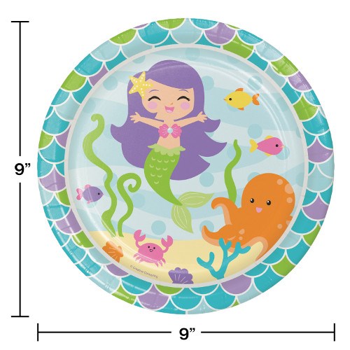 Round paper plate with scalloped mermaid scale border in blue and green, center showing a smiling purple-haired mermaid,.