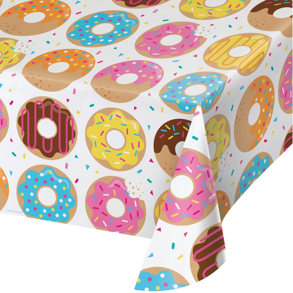 White tablecover featuring colorful frosted donuts with sprinkles in various colors and chocolate, pink, blue, yellow, and.
