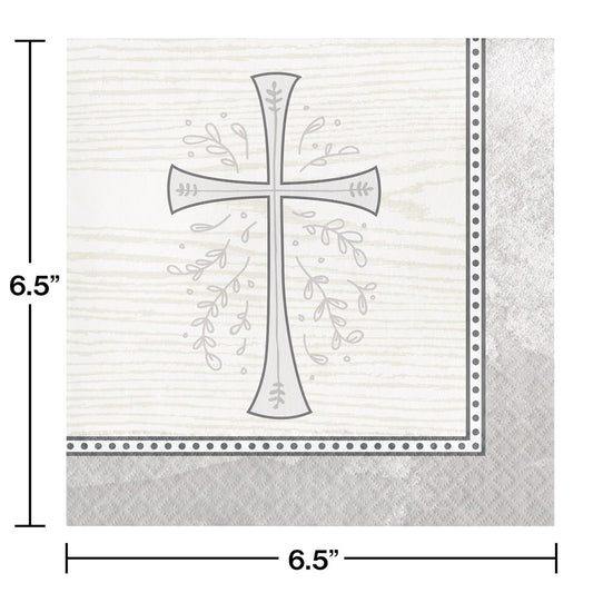 White square napkin with silver cross design surrounded by delicate leaf patterns and a dotted silver border.