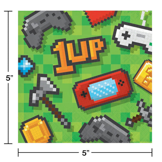 Green square beverage napkin with pixelated gaming icons including controllers, a heart, a pickaxe, gold coins, and the text