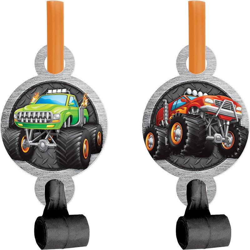 Two round monster truck-themed party blowouts with orange plastic mouthpieces, featuring green and red monster trucks on a.