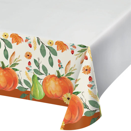 White paper tablecover with a border of orange pumpkins, green leaves, and autumn flowers.