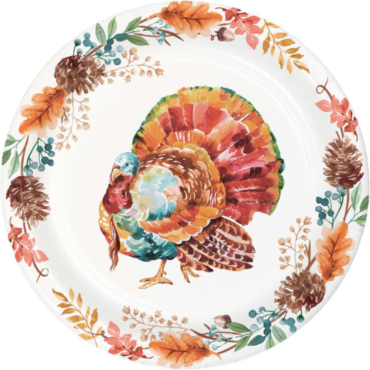 Round white paper plate with colorful turkey illustration at center and autumn leaves and pinecones around edge.