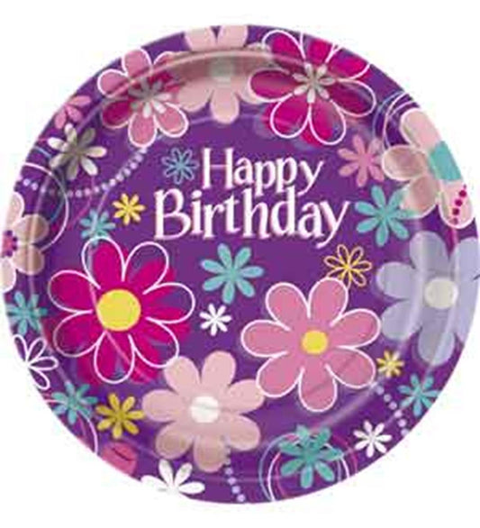 Purple round paper plate with colorful large floral patterns and "Happy Birthday" text in white centered.