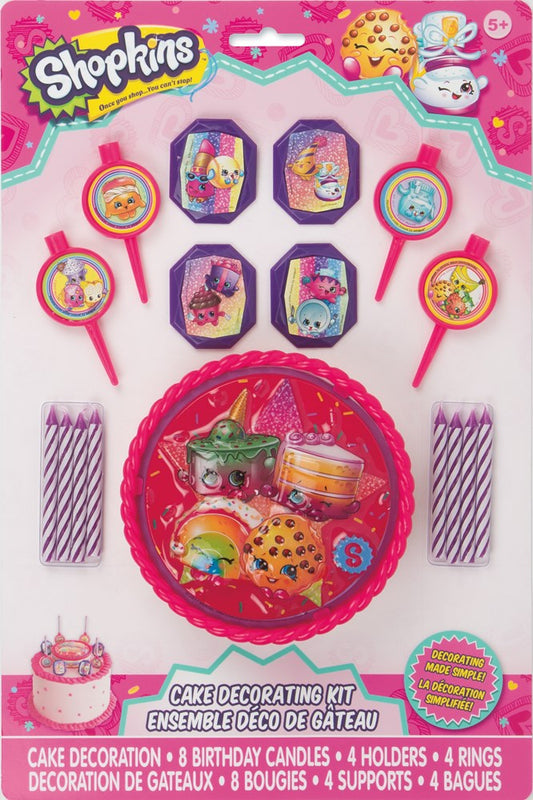 Shopkins cake decor kit with colorful character rings, candles, and four purple holders on pink backing card.