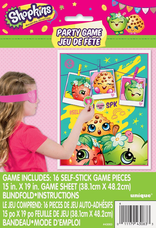 Colorful Shopkins-themed party game board with sticky game pieces and a pink blindfold on a child’s head.