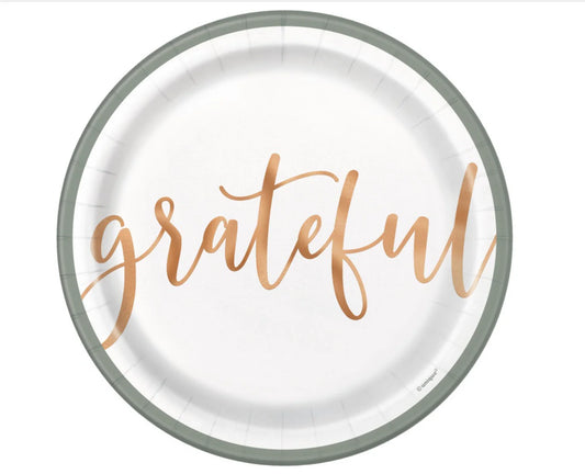Round white paper plate with soft gray rim and the word "grateful" in large cursive copper lettering centered.
