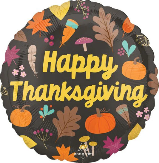 Round black foil balloon with yellow "Happy Thanksgiving" text and colorful fall leaves, pumpkins, mushrooms, and acorns.