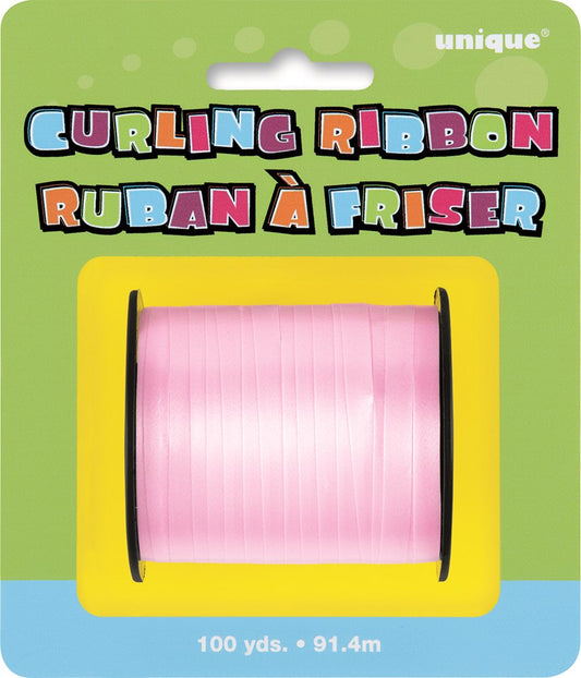 Pastel pink curling ribbon spool with a shiny, smooth finish on colorful packaging.