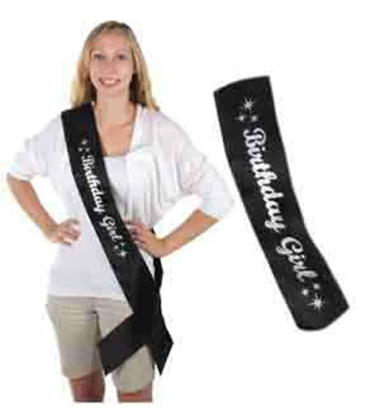 Black satin sash with white "Birthday Girl" text and star accents, worn diagonally across the body.