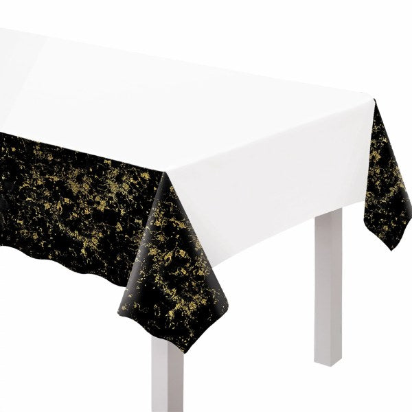 White rectangular plastic table cover with black and gold speckled edges for New Year celebration.