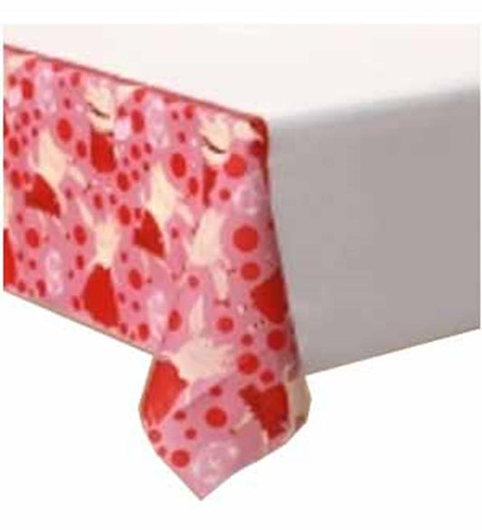 Red and pink floral patterned tablecloth draped over white rectangular table.