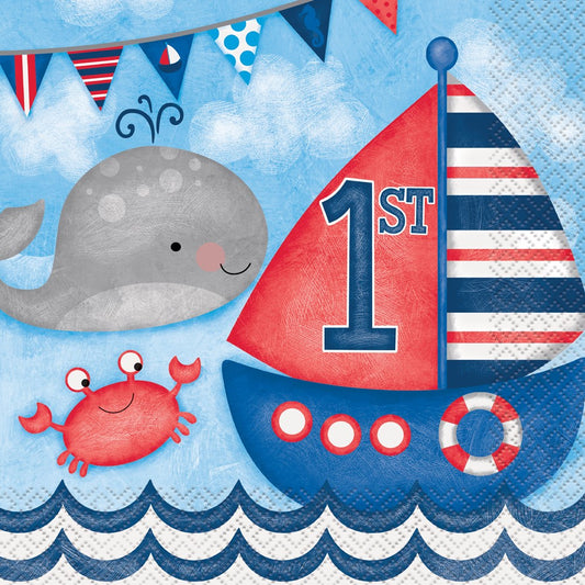 Blue and white square napkin with red and navy sailboat, gray whale, red crab, and "1st" text for nautical first birthday.