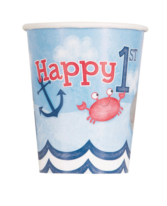 Blue paper cup with waves, red crab, navy anchors, and "Happy 1st" text for boys' birthday.