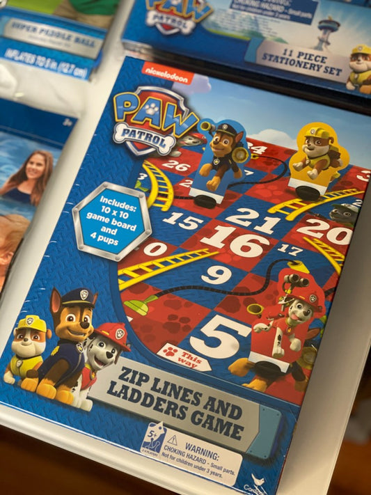Colorful Paw Patrol themed board game with ladder and number spaces, featuring characters Chase, Marshall, and Rubble.