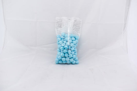 Clear plastic bag filled with small, round, shimmer-finished powder blue gumballs against a white background.