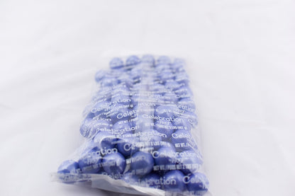 Clear plastic bag filled with shiny light purple spherical gumballs labeled Shimmer Gumballs Lavender.