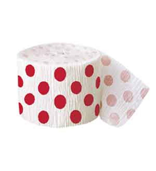 White crepe paper streamer with evenly spaced large red polka dots, rolled up with part unrolled.