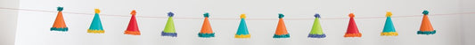 Colorful mini party hats strung on a 7ft garland with small white pom poms between each hat.